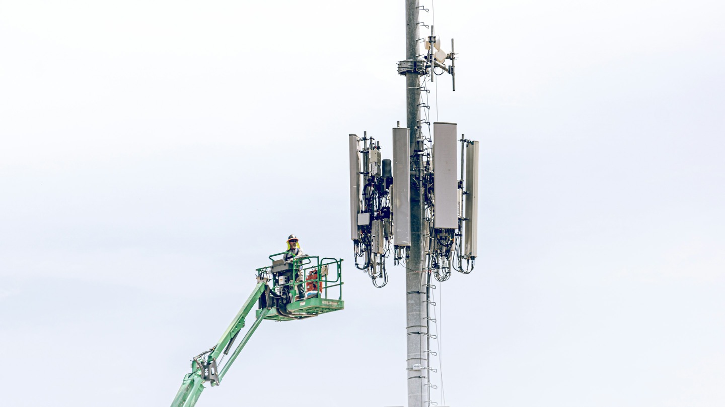 Monter na podnośniku przy maszcie telefonii komórkowej